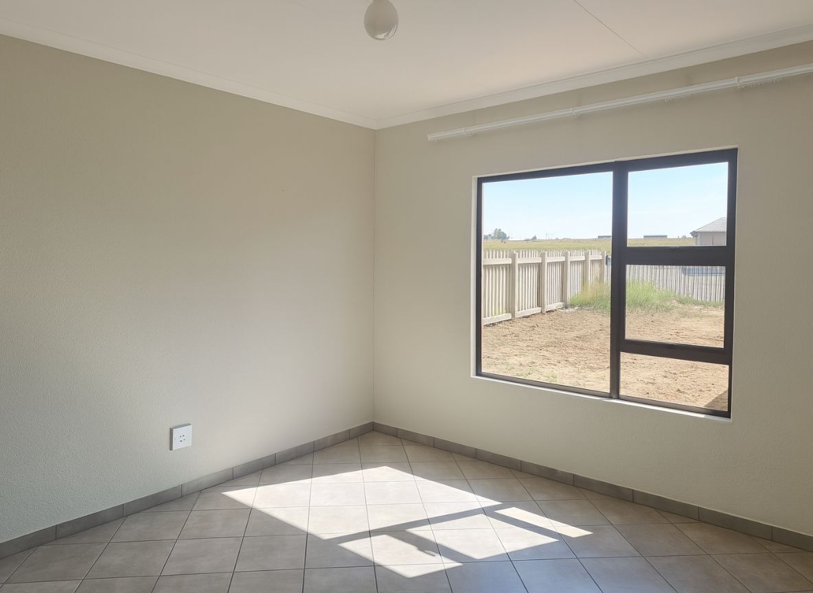 Bright bedroom with large window and modern grey floor tiles in the Crystal Park development.