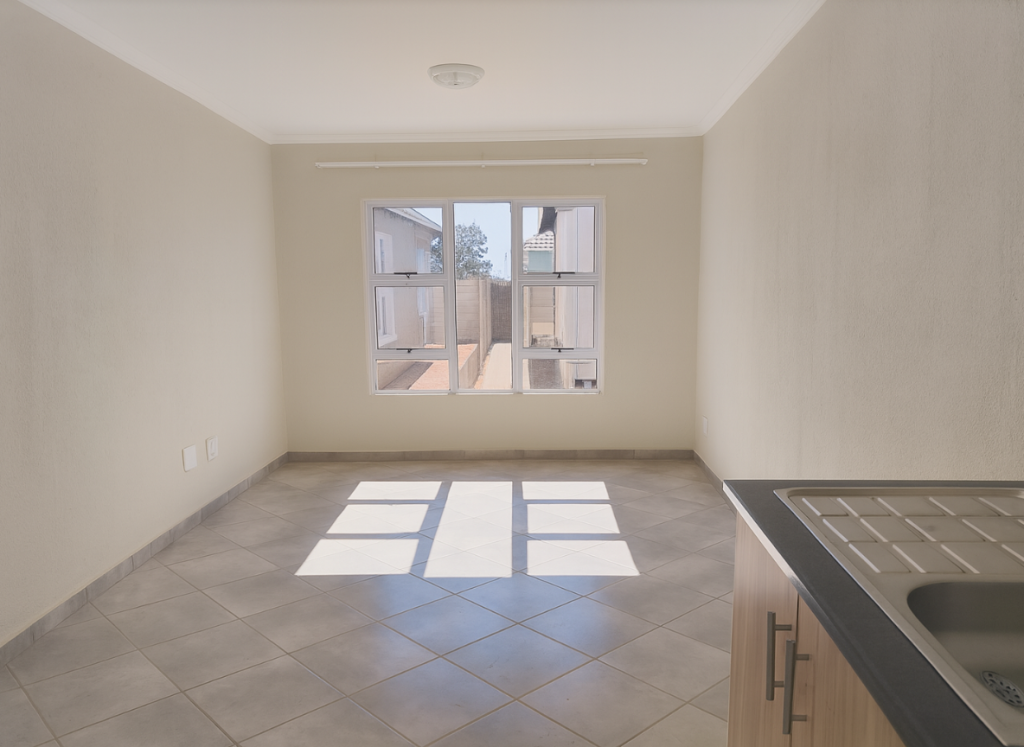 Living room at Greenwood Gardens with natural light, tiled floors and modern window design.
