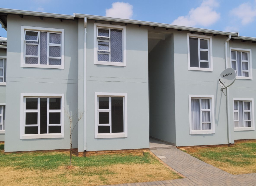 Modern apartment block at Greenwood Gardens in Germiston with well-kept lawns and walkway.