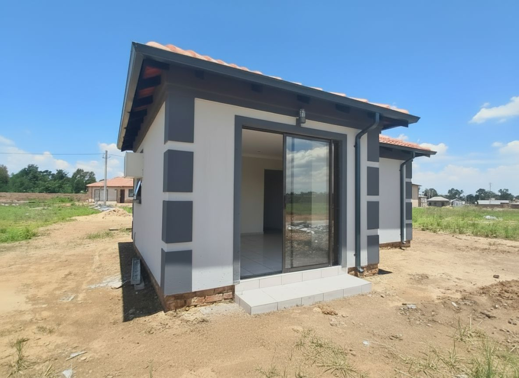 Side-angle exterior view of a new Selcourt home in Springs, featuring a sliding-door entrance, grey exterior trims and tiled roof.